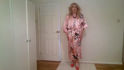 Stripping out of a pink kimono with white dress and stockings underneath